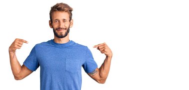 Yakışıklı, sakallı, sıradan kıyafetler giyen, kendine güvenen, gülümseyen, kendini gururlu ve mutlu gösteren bir adam.. 