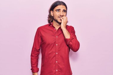 İş kıyafetleri giyen genç yakışıklı stresli ve gergin görünüyor. Ağzı tırnak yiyen elleri var. anksiyete. 