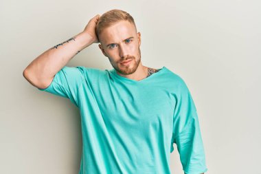 Günlük giysiler giyen genç beyaz bir adam soru sorup kafasını karıştırıyor. Şüpheyle kararsız, kafa kafaya düşünerek. Düşünceli kavram. 