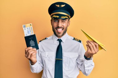 Elinde kağıt uçak ve pasaport tutan yakışıklı İspanyol pilot komik bir ifadeyle dilini dışarı çıkarıyor.. 