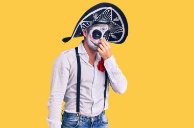 Arka planda ölü kostümü giymiş bir adam pis ve iğrenç bir koku alıyor. Nefesini burnunda tutuyor. Kötü kokuyor. 