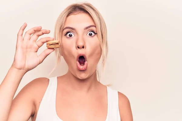 Joven Mujer Rubia Comiendo Postre Francés Sosteniendo Macaron Chocolate Sobre —  Fotos de Stock