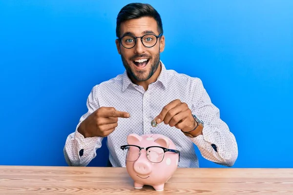 Hezký Hispánský Muž Drží Prasátko Banky Brýlemi Úsměvem Šťastný Ukazuje — Stock fotografie