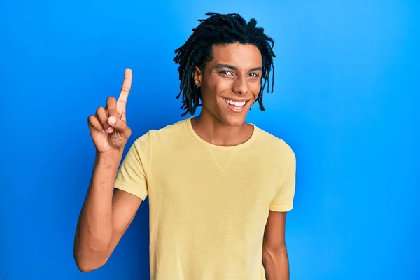 若いアフリカ系アメリカ人の男性は 幸せな顔で指を指差すアイデアや質問に笑顔でカジュアルな服を着て ナンバーワン — ストック写真