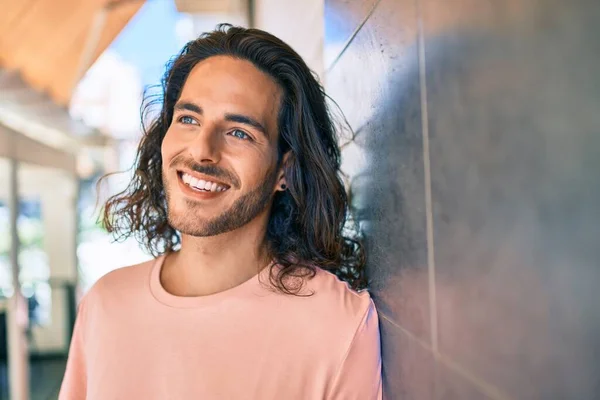 Joven Hombre Hispano Sonriendo Feliz Mirando Hacia Lado Apoyado Pared — Foto de Stock