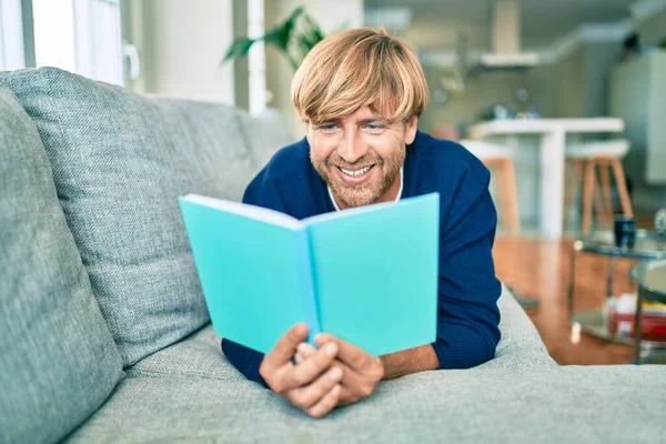 中年英俊的高加索男人在家里放松地看书 — 图库照片