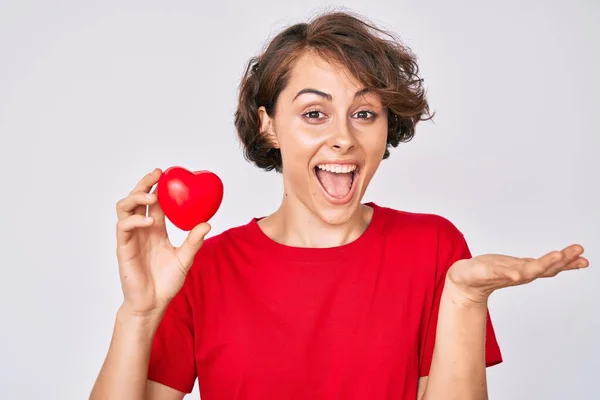 Mujer Hispana Joven Sosteniendo Corazón Celebrando Logro Con Sonrisa Feliz —  Fotos de Stock