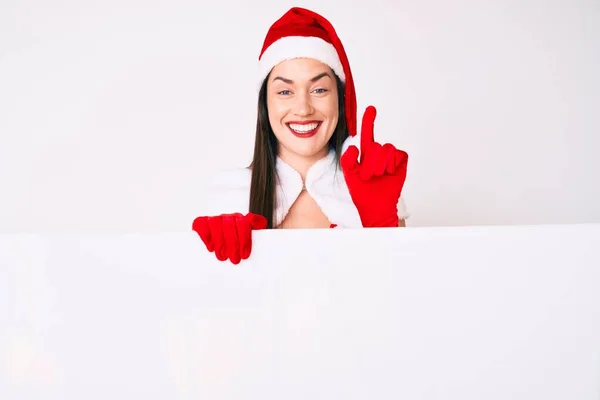 Young Woman Wearing Santa Claus Costume Holding Blank Empty Banner — Stock Photo, Image