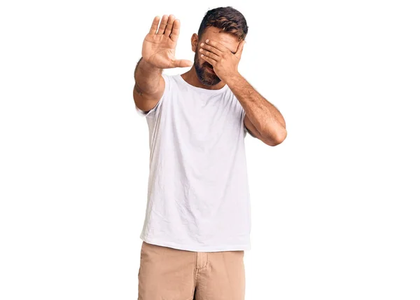 Young Hispanic Man Wearing Casual White Tshirt Covering Eyes Hands — Stock Photo, Image