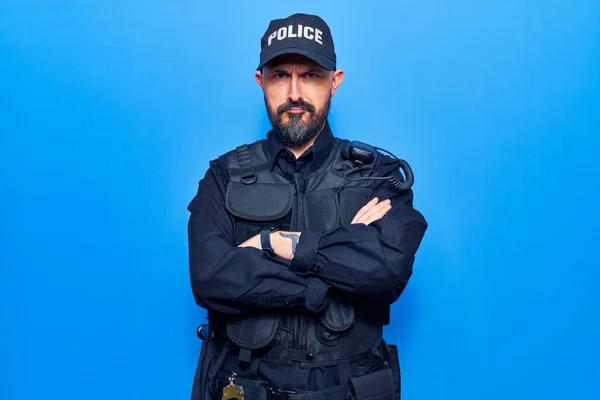 Young handsome man wearing police uniform skeptic and nervous, disapproving expression on face with crossed arms. negative person.