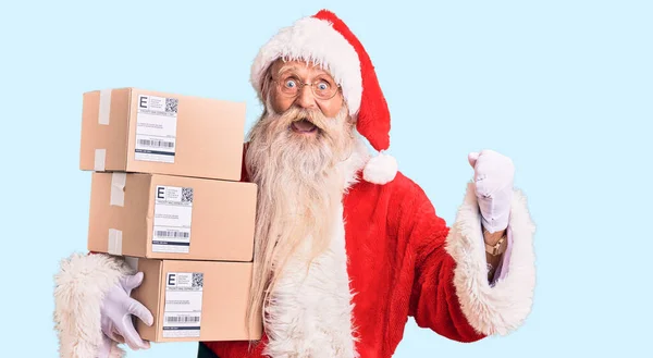 Staruszek Siwymi Włosami Długą Brodą Kostiumie Świętego Mikołaja Trzymający Pudełka — Zdjęcie stockowe