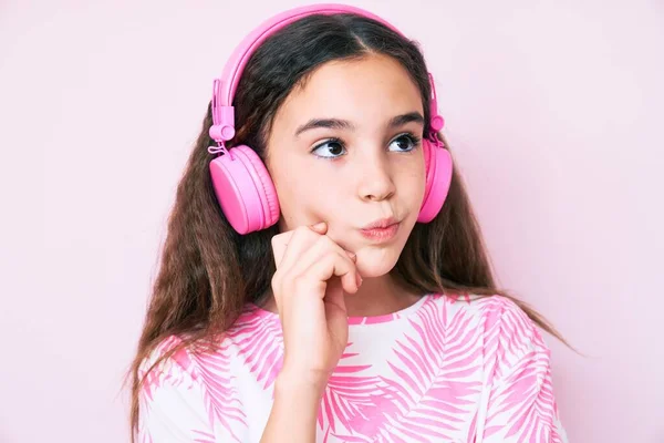 Linda Niña Hispana Escuchando Música Usando Auriculares Pensando Concentrada Duda —  Fotos de Stock