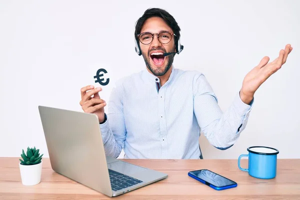 Hombre Hispano Guapo Trabajando Oficina Sosteniendo Pancarta Euro Celebrando Victoria —  Fotos de Stock