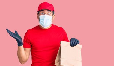 İspanyol asıllı genç adam elinde kağıt çantayla yemek getiriyor zaferi mutlu bir gülümsemeyle kutluyor ve kazanan yüz ifadesini kaldırarak ellerini kaldırıyor. 