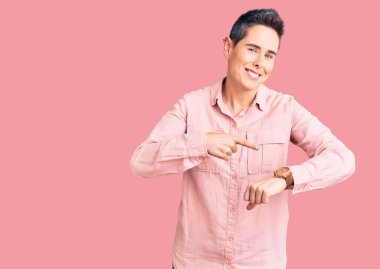 Kısa saçlı, günlük kıyafetler giyen genç bir kadın. Aceleyle saati, sabırsızlığı, son teslim tarihini geciktirdiği için üzgün ve kızgın olduğunu gösteriyor. 