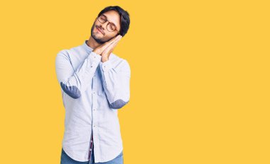 Yakışıklı, iş gömleği ve gözlük takan, yorgun uyuyan, hayal kuran ve elleriyle poz veren, kapalı gözlerle gülümseyen bir İspanyol.. 