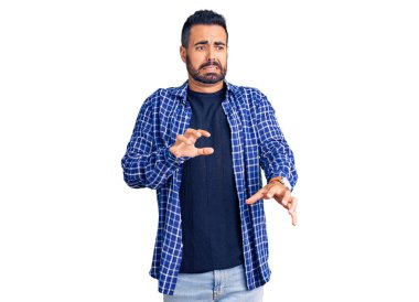 Gündelik kıyafetler giyen genç İspanyol adam tiksindirici bir ifade takınıyor ve tiksindirici bir yüz ifadesi takınıyor.. 