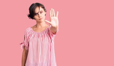 Kısa saçlı, günlük kıyafetleri olan güzel bir kadın avucunun içi gibi şarkı söylemeyi kesiyor. Yüzünde olumsuz ve ciddi bir jest olan uyarı ifadesi. 