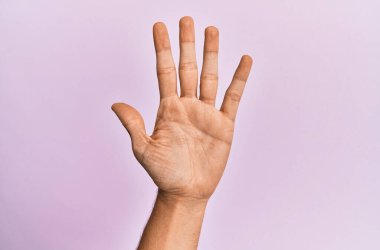 Pembe izole edilmiş arka planda beyaz bir gencin kolu ve eli beş parmağı gösteriyor. 