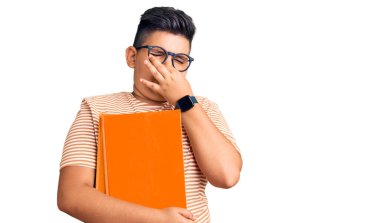 Küçük çocuk kitap tutuyor, gözlük takıyor. Kokuşmuş ve iğrenç bir koku alıyor. Dayanılmaz bir koku. Kötü kokuyor. 