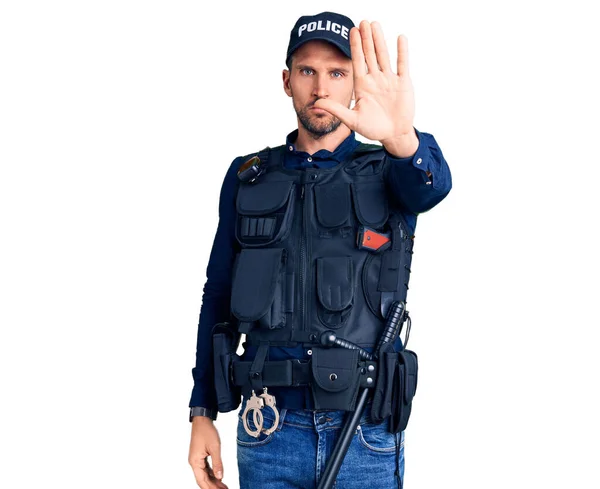 年轻英俊的男子穿着警服 手掌心停止歌唱 用消极而严肃的手势警告人 — 图库照片