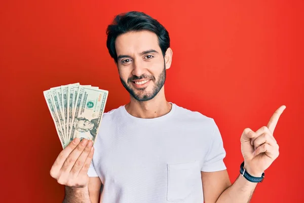 Fiatal Spanyol Férfi Kezében Dolláros Bankjegy Mosolyog Boldogan Mutatva Kéz — Stock Fotó