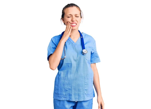 歯の痛みや歯の病気のために痛みを伴う式で手で医師の制服や聴診器を触れる口を身に着けている若い美しいブロンドの女性 歯科医 — ストック写真