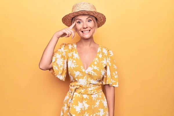 Piękna Blondynka Wakacjach Letniej Czapce Sukience Żółtym Tle Uśmiechnięta Wskazując — Zdjęcie stockowe