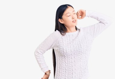 Genç, güzel Çinli kadın, rahat, yorgun, uykulu ve sabahları esneyen, rahat bir süveter giyiyor. 