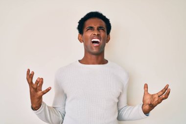 Sıradan bir kazak giyen Afrikalı yakışıklı deli deli deli bağırıyor ve agresif bir ifade ve kollarla bağırıyor. hüsran kavramı. 