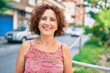 Orta yaşlı bir kadın gülümseyerek mutlu bir şekilde yürüyordu..