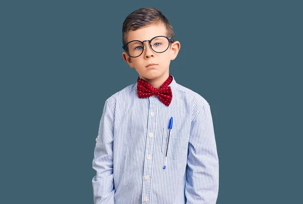 可爱的金发碧眼的孩子戴着书呆子领结和眼镜 脸上有严肃的表情 简单而自然地看着相机 — 图库照片