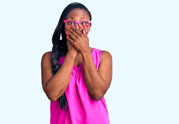 Młoda Afroamerykanka Luźnych Ciuchach Okularach Szoku Zakrywająca Usta Rękami Przez — Zdjęcie stockowe