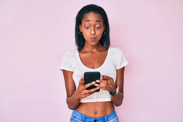 Mujer Afroamericana Joven Usando Teléfonos Inteligentes Hinchando Mejillas Con Cara —  Fotos de Stock