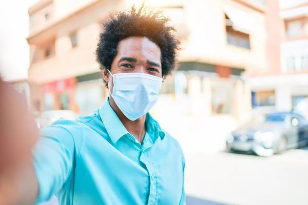 若いハンサムなアフリカ系アメリカ人の男性がカジュアルな服や医療マスクを着ている 街中のカメラで自撮り — ストック写真