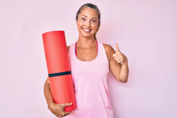 Orta Yaşlı Spanyol Kadın Elinde Yoga Minderiyle Mutlu Pozitif Gülümsüyor — Stok fotoğraf