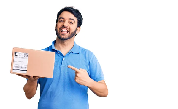 Jonge Spaanse Man Houdt Levering Pakket Glimlachend Gelukkig Wijzend Met — Stockfoto