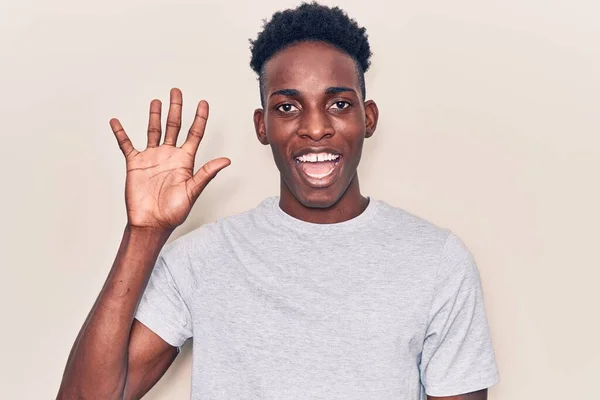 自信を持って幸せな笑顔ながら 若いアフリカ系アメリカ人の男性は カジュアルな服を着て指の数5を示すと指摘 — ストック写真