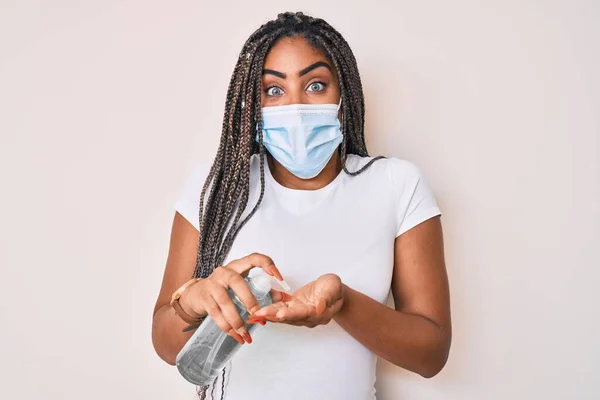 Νεαρή Αφροαμερικανή Γυναίκα Πλεξούδες Φορώντας Ιατρική Μάσκα Χρησιμοποιώντας Απολυμαντικό Χεριών — Φωτογραφία Αρχείου