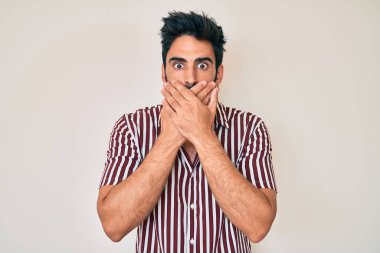 Sıradan kıyafetler giyen yakışıklı, sakallı, ağzı yanlışlıkla elleriyle kapatan bir İspanyol. gizli kavram. 