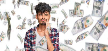 Günlük kıyafetler giyen genç İspanyol adam diş ağrısı ya da diş hastalığından dolayı acı dolu bir ifadeyle ağıza dokunuyor. dişçi