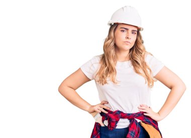 Güvenlik kaskı takan beyaz kadın yüzünde ciddi bir ifadeyle rahatlamış. Basit ve doğal bir şekilde kameraya bakıyorsun.. 