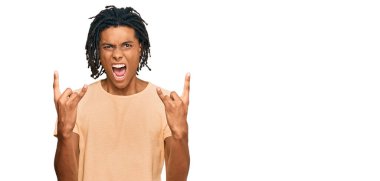 Sıradan kıyafetler giymiş, çılgın bir ifadeyle bağıran, elleri havada rock sembolü yapan genç bir Afrikalı Amerikalı. Müzik yıldızı. ağır kavram. 