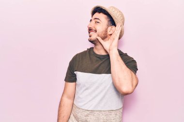 Gündelik kıyafetler giyen, ağzı kulaklarında gülümseyen, dedikoduları ve dedikoduları dinleyen genç İspanyol bir adam. Sağırlık kavramı. 