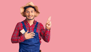 Yakışıklı, Latin Amerikalı, üniforma giyen, gülümseyen, elleri göğsünde ve parmakları havada yemin eden, sadakat yemini eden genç adam. 