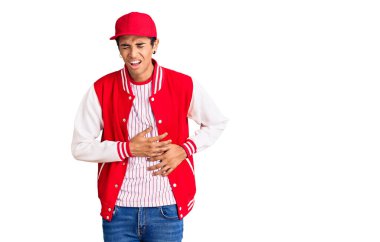 Genç Afro-Amerikalı bir adam elleri karnında beyzbol forması giyiyor çünkü mide bulantısı, acı verici bir hastalık kendini iyi hissetmiyor. Ağrı kavramı. 