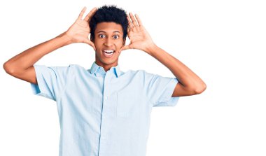 Genç Afro-Amerikalı günlük kıyafetler giymiş neşeli gülümseyen ve elleri havada bir böceği dikizleyen bir adam. Şaşırdım ve çıktım. 