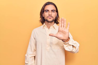 İş kıyafetleri giymiş genç yakışıklı bir adam avucunun içinde şarkı söylemeyi kesiyor. Yüzünde olumsuz ve ciddi bir jest olan uyarı ifadesi. 