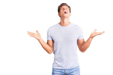 Gündelik kıyafetler giyen genç, çılgın ve çılgın başarıyı kutlayan kollarını kaldırmış, gözlerini kapatmış heyecanlı çığlıklar atan yakışıklı bir adam. Kazanan konsept 