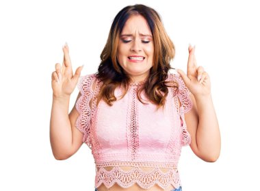 Genç, beyaz, sıradan kıyafetler giyen, umut dolu ve gözleri kapalı bir şekilde el işareti yapan güzel bir kadın. Şans ve batıl inançlar. 